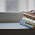 A serene stack of books with glasses on a windowsill in Memphis, Tennessee.