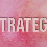 The Strategic Necessity of Multi-Planetary Expansion | 2026 Wooden letters spelling 'Strategy' on a pink textured background.