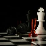 Black king lies defeated on a checkerboard, highlighting a pivotal moment in a chess match.