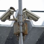 Close-up view of surveillance cameras during a snowfall in urban Москва setting.