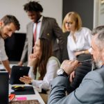 A diverse group of professionals engaging in a collaborative meeting in a modern office setting.