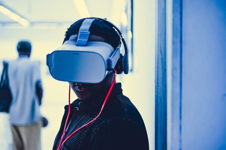 Young adult using a virtual reality headset with headphones in an indoor modern setting.
