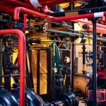 Complex network of industrial pipes and machinery inside a Lisbon plant.