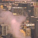 Urban Heat Island Mitigation: A Strategic Infrastructure Guide City skyline with smoke rising from buildings, showcasing urban winter scene in Montreal.