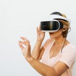Why Augmented Reality Fails: The Need for Spatial Persistence Woman using a VR headset immersed in a virtual reality world, with a white background.