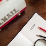 Why Ideology Is Your Organization's True Operating System Open book with 'Building Your Business Plan' text, pencils, and U.S. Mail bag on a wooden desk.