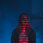 Zero-Knowledge Proofs: The Future of Trustless Decision-Making A mysterious silhouette with red binary code projected over the face, set against a dark, moody background.